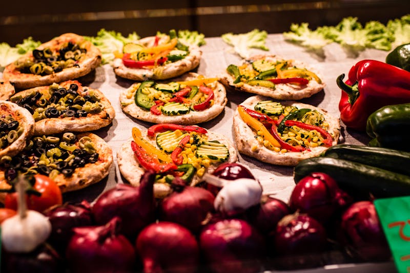Homemade pizza sauce being spread on dough
